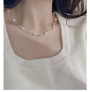 Detail of S925 silver wavy bar and freshwater pearl necklace worn on collarbone