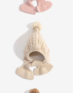 Detail view of winter knitted baby hat with soft textures and fuzzy pom pom trim