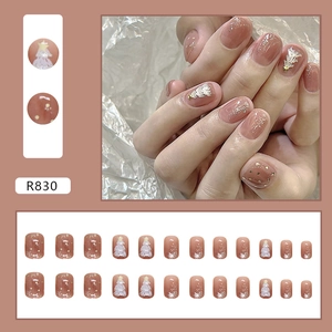 Uñas postizas navideñas marrón nude con árboles blancos en relieve y copos de nieve