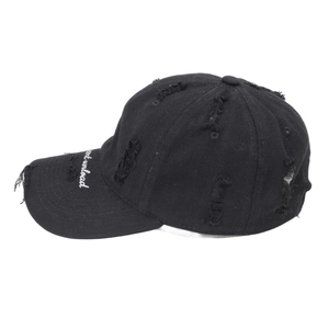 Detail shot of distressed black baseball cap with brim embroidery and worn-out fabric