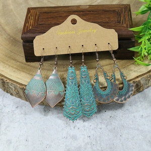 Close-up of three pairs of vintage Bohemian earrings with bronze metal and turquoise enamel