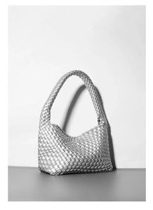 Dettaglio di una borsa hobo intrecciata argento con finitura metallica e trama in pelle