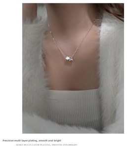 Detail view of a sterling silver rain cloud pendant with white shell inlay on female model
