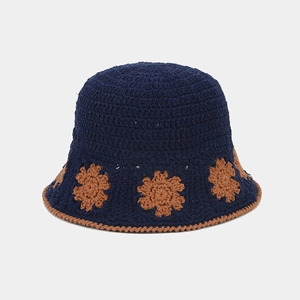 Detailed view of hand-knitted navy bucket hat featuring brown floral crochet patterns