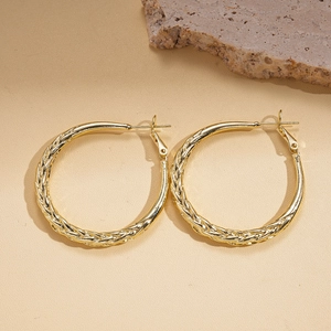 Minimalist gold geometric twisted round earrings with textured metallic finish