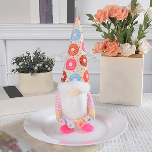 Plush Christmas gnome with donut pattern hat and white beard on a decorative plate