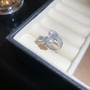 Detailed view of silver open ring featuring double pearls and shimmering pavé zircons