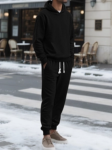 Detail of black hooded tracksuit featuring premium diamond knit texture on high-quality fabric