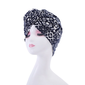 Detailed close-up of navy blue and white geometric print turban with spiral flower knot