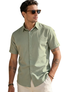 Detail of the olive green linen blend shirt showing the textured fabric and buttoned collar