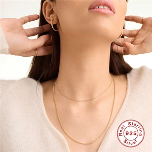 Elegant 925 sterling silver layered gold chain necklace shown on a fashion model