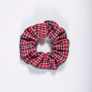 Close-up of red and black plaid fabric texture and elastic pleats on the scrunchie