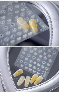Close-up of TL-217 heart-shaped shell luster nail stickers on soft yellow manicure