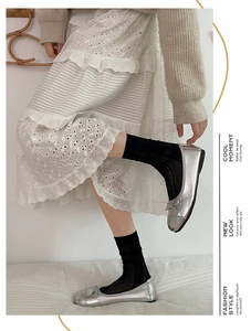 Detailed shot of breathable hollow-out knit crew socks styled with silver ballet flats