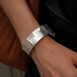 Détail macro du large bracelet manchette argenté avec motifs gaufrés et ouverture en C