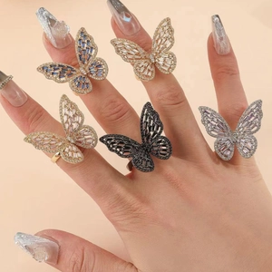 Five butterfly zircon rings in gold, silver, and rose gold on model hand