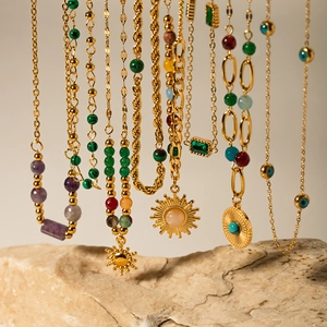Close-up of 18K gold plated chains with colorful turquoise beads and evil eye pendants