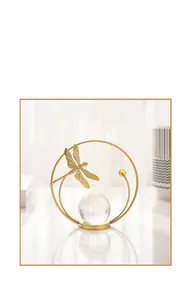 Detailed view of a golden dragonfly sculpture with a crystal ball on a metal ring