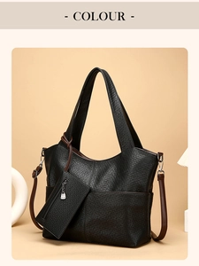 Detail view of black textured tote bag with matching coin pouch and dark brown strap