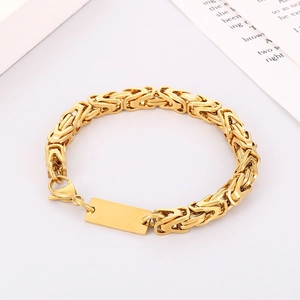 Close-up of golden Byzantine chain with blank rectangular ID tag and secure lobster clasp