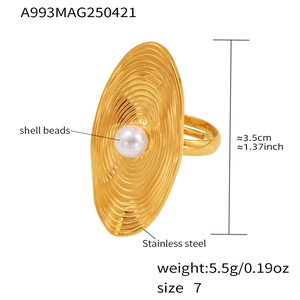 Macro detail of gold stainless steel ring with ripple texture and shell bead center