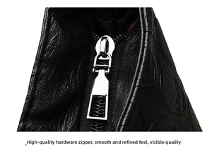 Macro shot of silver metal zipper and textured litchi leather on black tote bag