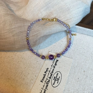 Detailed view of purple zircon beaded bracelet with gold accents and lobster clasp