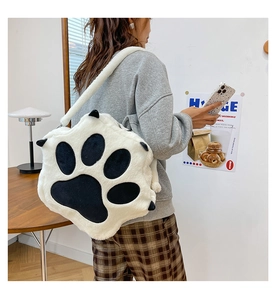 Detail of white plush cat paw shoulder bag with black pads and soft faux fur texture