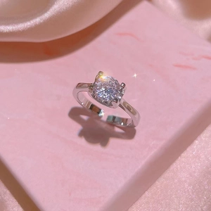 Luxurious silver ring set with large round zircon on pink silk fabric background