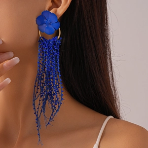 Detailed view of bold dark blue beaded fringe earrings with matte flower stud and gold hoop