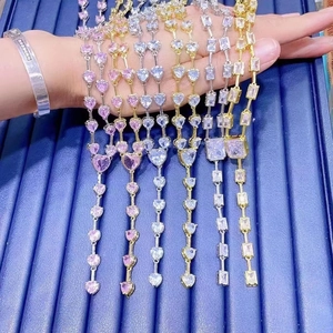 Close-up of pink and clear heart-shaped gemstone necklaces in gold and silver plating