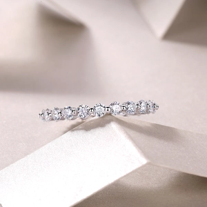 Detail of S925 silver ring with round moissanite row setting on a cream background