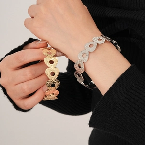Detail of heart-shaped hollow metal cuff bracelet with hammered texture finish