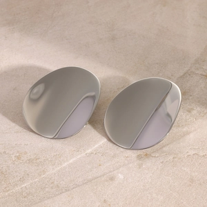 Macro detail of polished silver concave oval earrings with metallic mirror finish