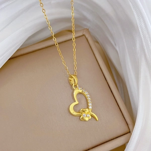 Elegant gold titanium heart clover necklace with crystals on silk and jewelry box display