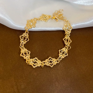 Detail shot of golden hollow heart links and lobster clasp with adjustable chain
