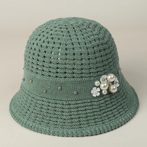 Detail of grey-green knit bucket hat featuring delicate hollow-out pattern and pearl accents