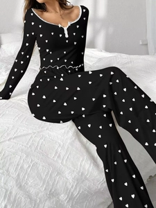 Detail of black rib-knit pajama set featuring white heart prints and lace trim collar