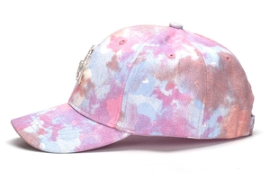 Side view of tie-dye baseball cap featuring rhinestone letter logo and 6-panel structure