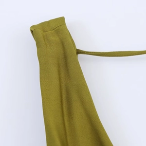 Detail of the olive green satin strap stitching and fine knit texture on the dress