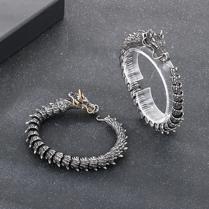 Vintage punk dragon bone bracelet in stainless steel with green eyes and golden accents