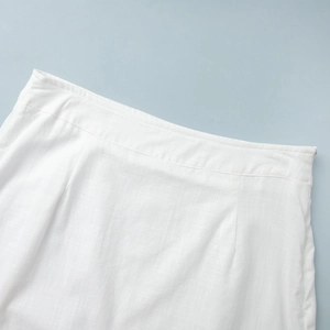 Detail of white cotton skirt waist with hidden side zipper and fine weave texture
