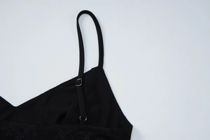 Close-up detail of delicate black lace trim and adjustable thin strap on a dress