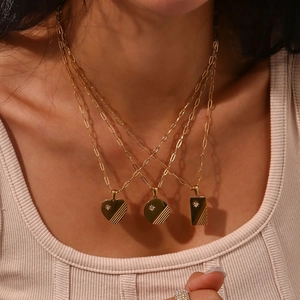 Detailed close-up of triple-layered gold-plated necklaces with geometric starburst pendants