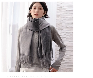 Detailed texture of thick grey gradient cashmere scarf with long tassels and knit pattern