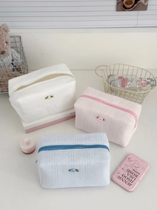Detailed view of quilted cotton cosmetic bags with 3D ribbon flowers and zipper closure