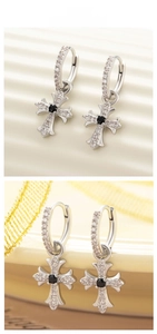 Detail shot of vintage silver cross earring with black gemstone and white zirconias