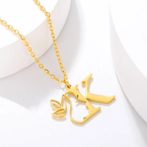 Close-up of gold-plated stainless steel necklace with artistic letter K and leaf pendant