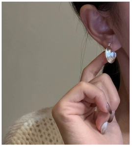 Close-up of minimalist S925 sterling silver hoop earring with a matte frosted finish