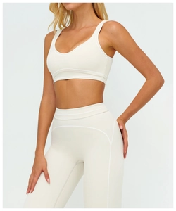 Detail view of cream-colored two-piece yoga set with U-neck bra and high-waist leggings